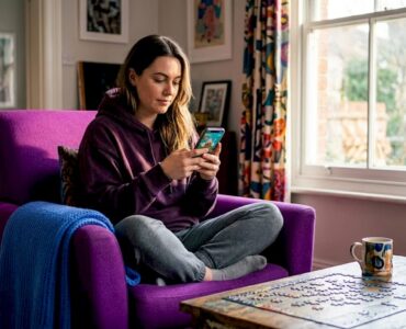 Mobile gamer watches reward ad on sofa